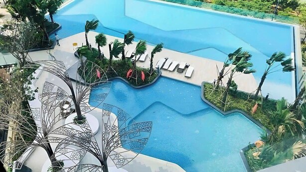 A swimming pool with lounge chairs and palm trees. - Apartments in District 2-The Sun Avenue (Ho Chi Minh City)
