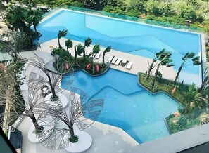 A swimming pool with lounge chairs and palm trees. - Apartments in District 2-The Sun Avenue (Ho Chi Minh City)