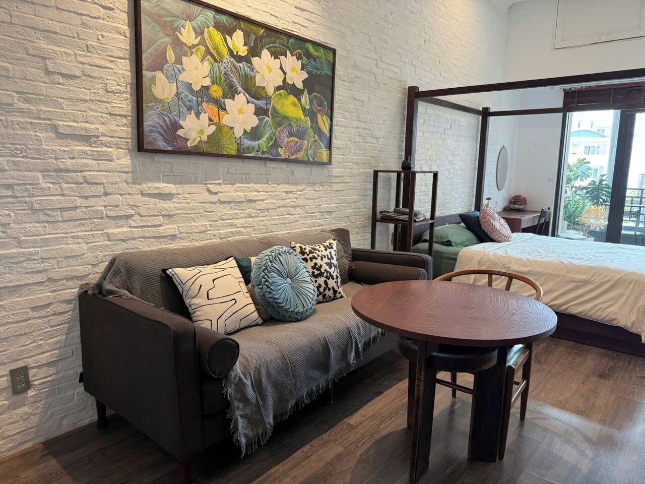 Una habitación con sofá, una mesa redonda y una cama.