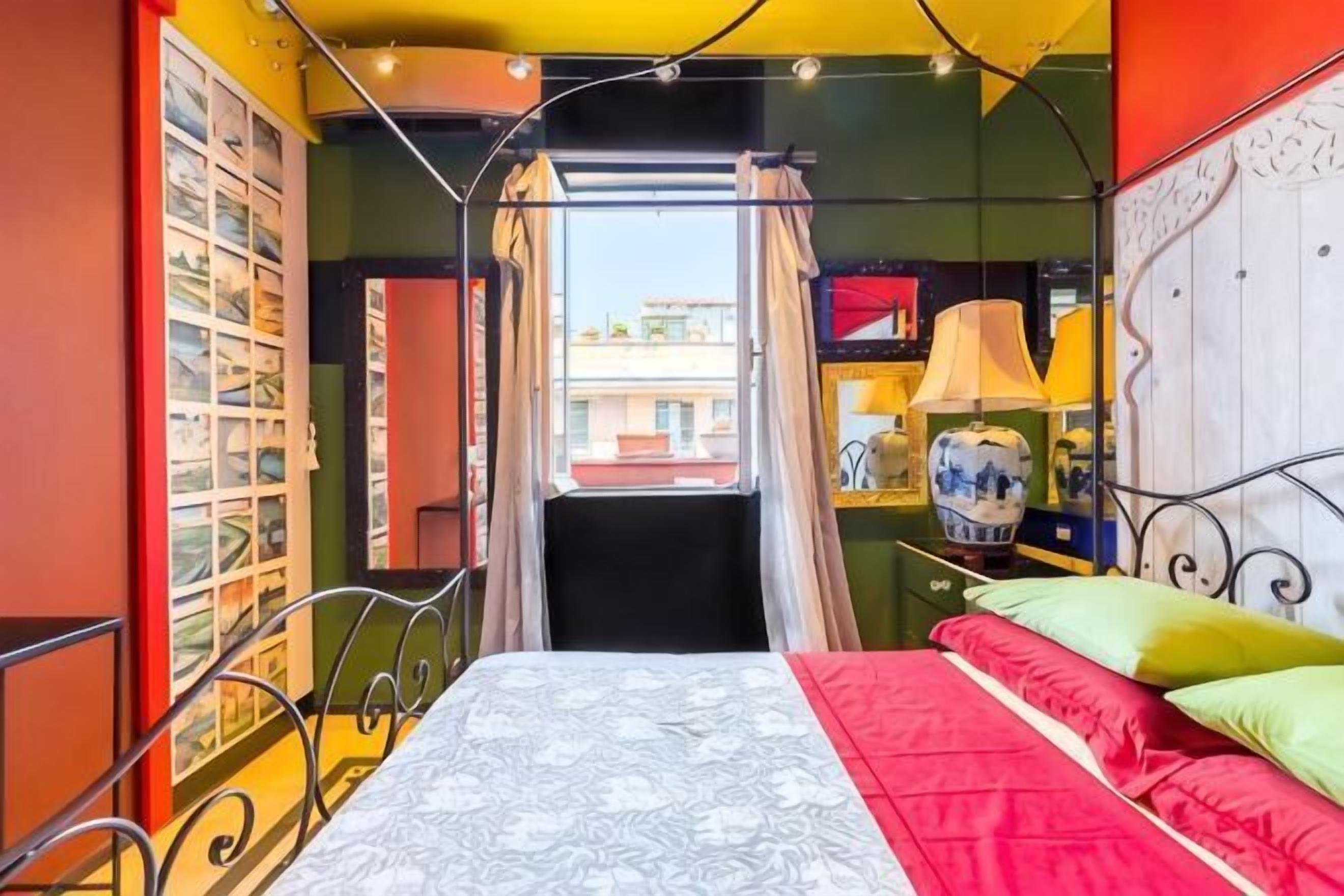 Una camera da letto con un letto, tende, una finestra e una libreria.