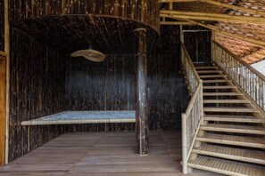 A wooden interior with a staircase leading to a balcony. - Clan Living - the Lovers Ubud Private Villas (Bali)