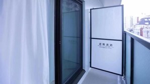 A narrow corridor with a sliding glass door and a whiteboard with text. - japan house sugamo (Tokyo)