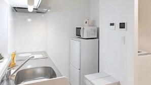 A compact kitchen with a sink, a microwave, and a refrigerator. - japan house sugamo (Tokyo)