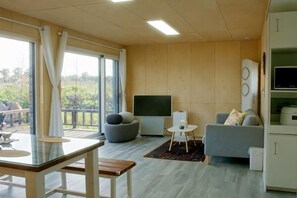 A modern living room with a glass table, grey sofa, and a TV. - Thechaeum (Seogwipo)