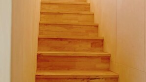 A wooden staircase with a handrail on the left side. - Thechaeum (Seogwipo)