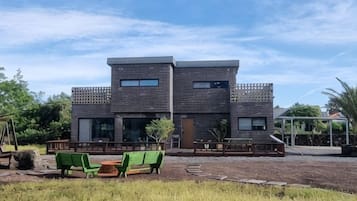 A modern two-story building with a flat roof and a balcony.