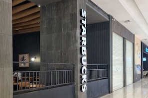 A Starbucks store with a closed shutter, a metal railing, and a dark interior. - Near Ferry Terminal. COZY 02 Bedroom Condo. HarbourBay Residences. (Batu Ampar)