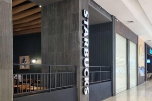 A Starbucks store with a closed shutter, a metal railing, and a dark interior. - Near Ferry Terminal. COZY 02 Bedroom Condo. HarbourBay Residences. (Batu Ampar)