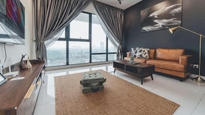 A modern living room with a large window, a brown sofa, a coffee table, and a TV on a wooden cabinet.