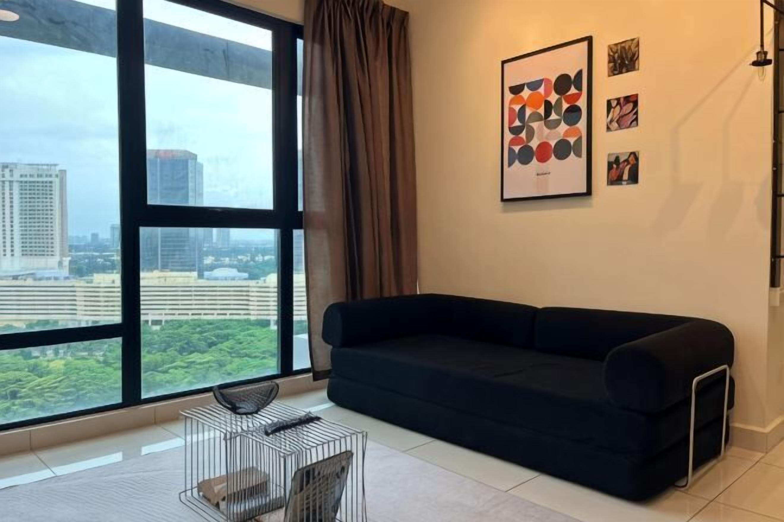 Ein modernes Wohnzimmer mit einer schwarzen Couch, einem Metall-Couchtisch und einem großen Fenster mit Blick auf die Stadt.