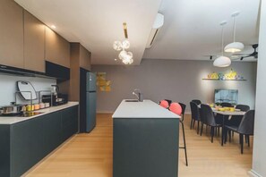 Una cocina moderna con una isla central, un comedor con sillas y una isla de cocina con fregadero.