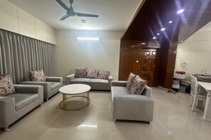 A modern living room with a sofa set, a coffee table, and a ceiling fan. - Mahir's Cozy Den (Dhaka)