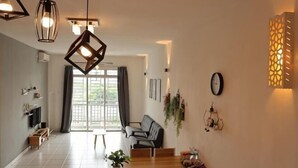 Een moderne eetruimte met een houten tafel, stoelen, hanglampen en uitzicht door een glazen deur op een buitenruimte.
