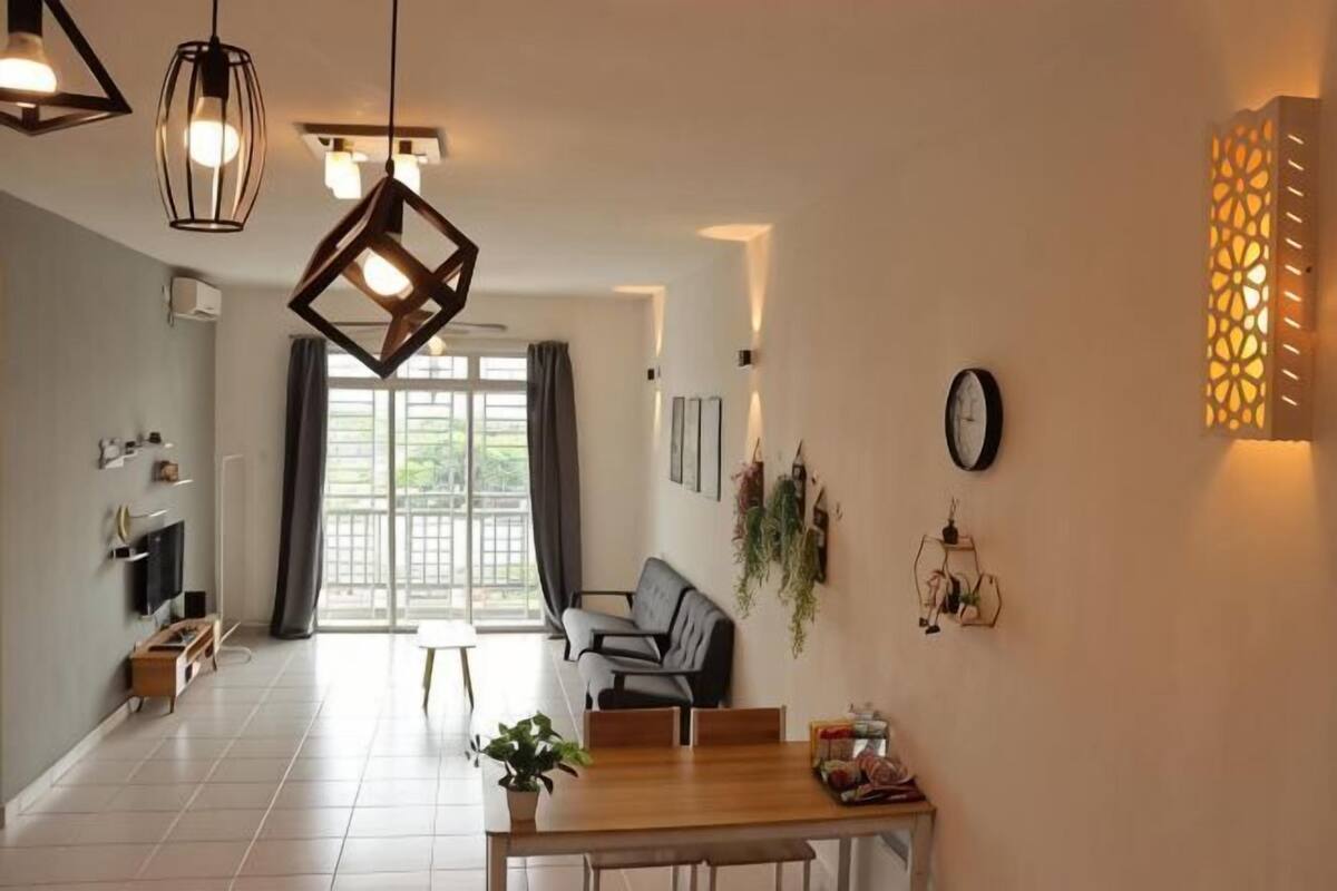 Een moderne eetruimte met een houten tafel, stoelen, hanglampen en uitzicht door een glazen deur op een buitenruimte.