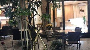 A lobby with a reception desk, seating area, and potted plants.