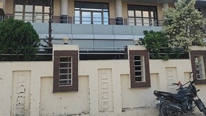 A hotel named Royal Kristina with multiple floors, large windows, and a parking area with a motorcycle. - Hotel Royal Krishna (Gorakhpur)
