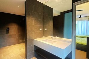 A modern bathroom with a large white sink, dark tiled walls, and a shower area. - The Luxurious 231, Lake House Villa (Pegoh)