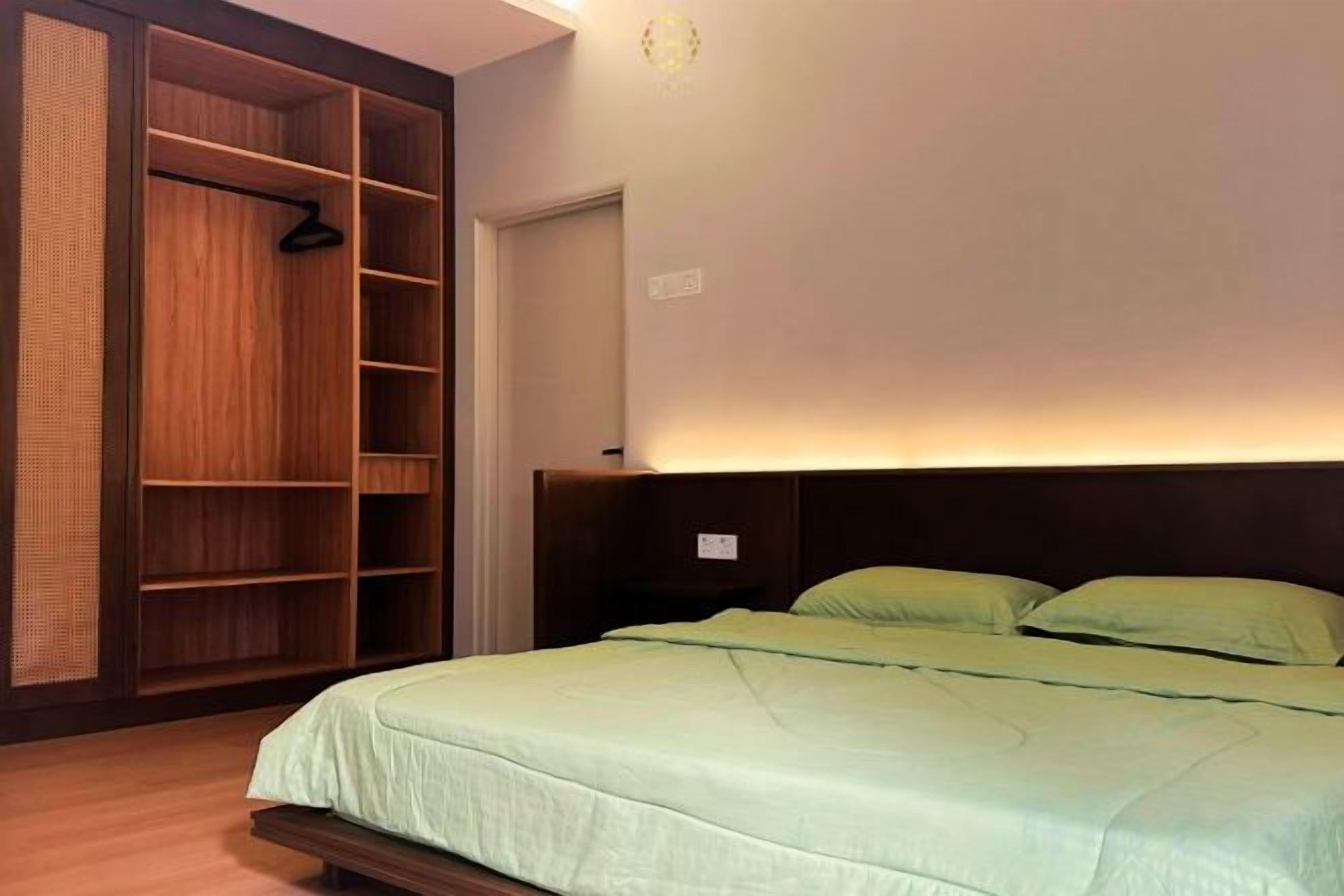 A bedroom with a bed, a wardrobe, and a nightstand.