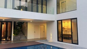 A modern two-story building with a swimming pool, glass doors, and a staircase leading to the upper floor. - The Luxurious 231, Lake House Villa (Pegoh)