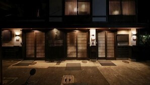 A two-story building with a traditional design, featuring sliding doors and a well-lit entrance. - Shiki Homes Ikko 9 (Kyoto)