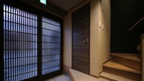 A traditional Japanese room with sliding doors, a wooden staircase, and a dark-toned wardrobe. - Shiki Homes Ikko 9 (Kyoto)