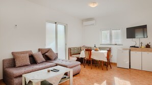 A compact living space with a sofa, a dining table, and a television. - Villa Katarina - Peroj by Villas Guide (Peroj)