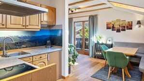 A kitchen with wooden cabinets, a built-in stove, and a view of mountains through a window.