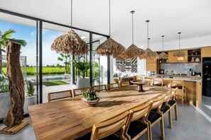 A modern kitchen with a large island, pendant lights, and a view of the outdoors. - Villa Nature View by BaliSuperHost (Bali)