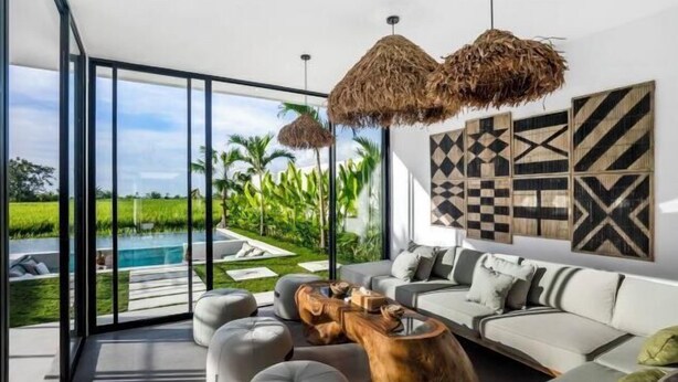 A modern living room with a large glass wall, a pool, and a wooden coffee table. - Villa Nature View by BaliSuperHost (Bali)