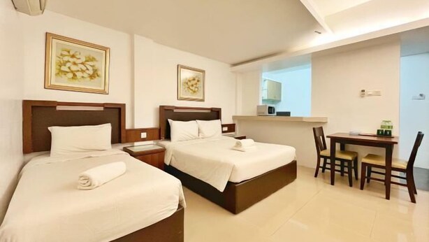 A hotel room with two beds, a desk, and chairs. - Official Khalifa Suites Hotel & Apartment (Kota Bharu)