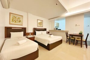 A hotel room with two beds, a desk, and chairs. - Official Khalifa Suites Hotel & Apartment (Kota Bharu)