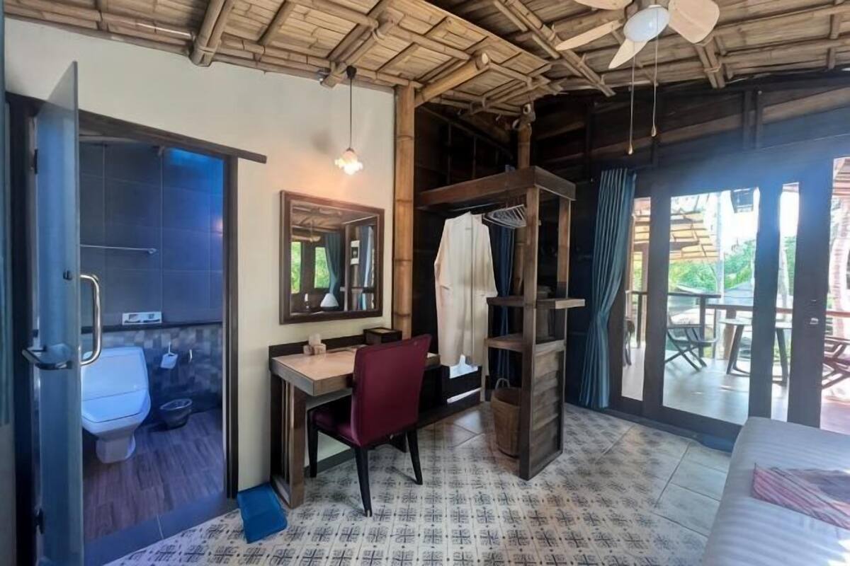 Une chambre équipée d’une douche, de toilettes, d’un bureau, d’une chaise et d’un lit.