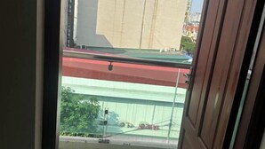 A view from a balcony with a metal railing, a red and green roof, and a building in the background. - Qing Xian Homestay (Bac Ninh)
