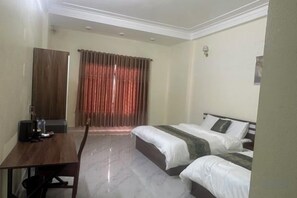 A hotel room with a bed, a desk, and a wardrobe. - Qing Xian Homestay (Bac Ninh)