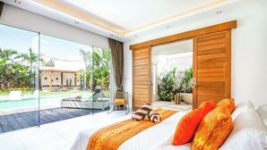 A modern bedroom with a large bed, a sliding glass door to a pool area, and a view of the outdoors. - Canggu CAROLE · (Bali)