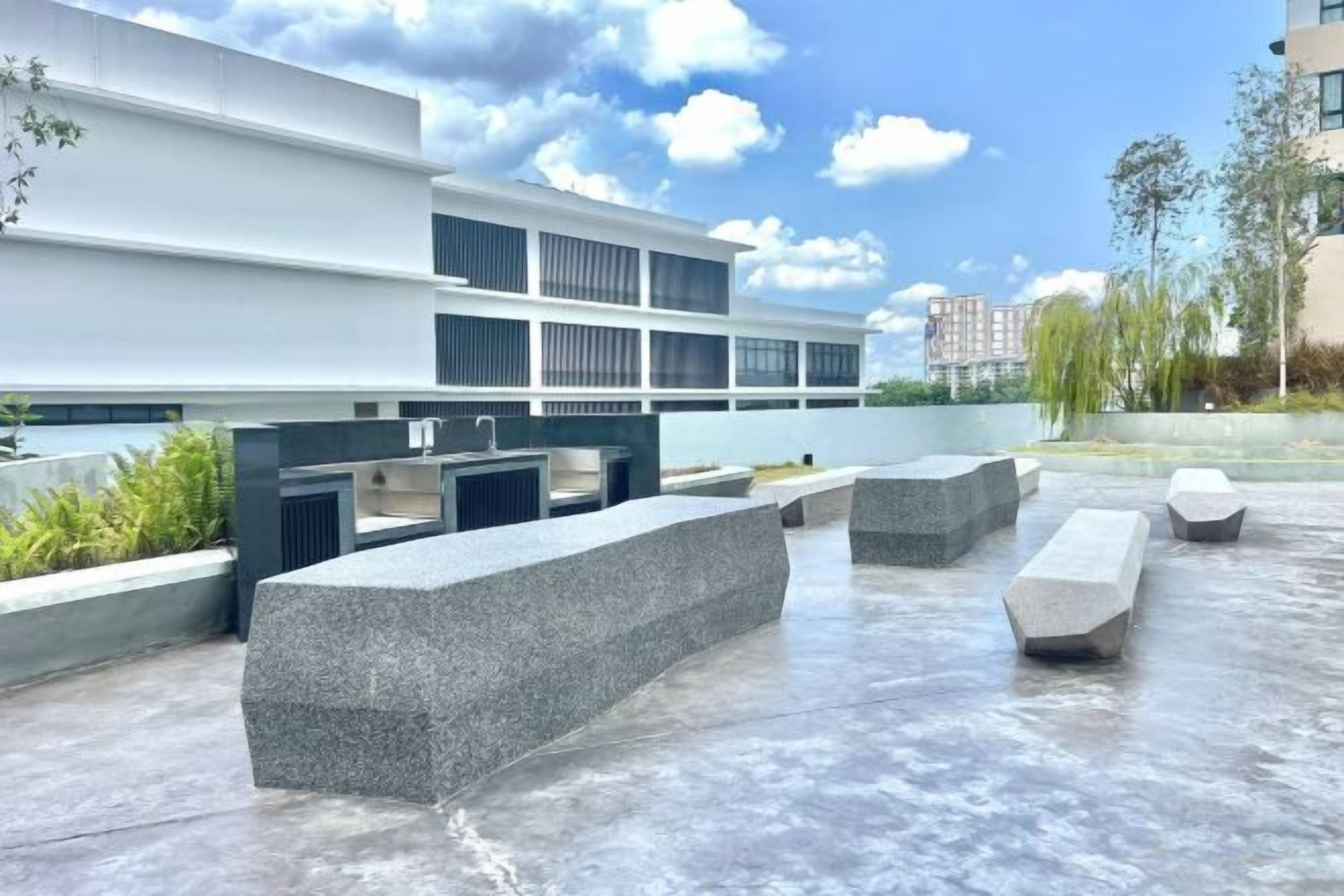 Eine Terrass mit Sitzgelegenheiten und einem Wasserspiel.