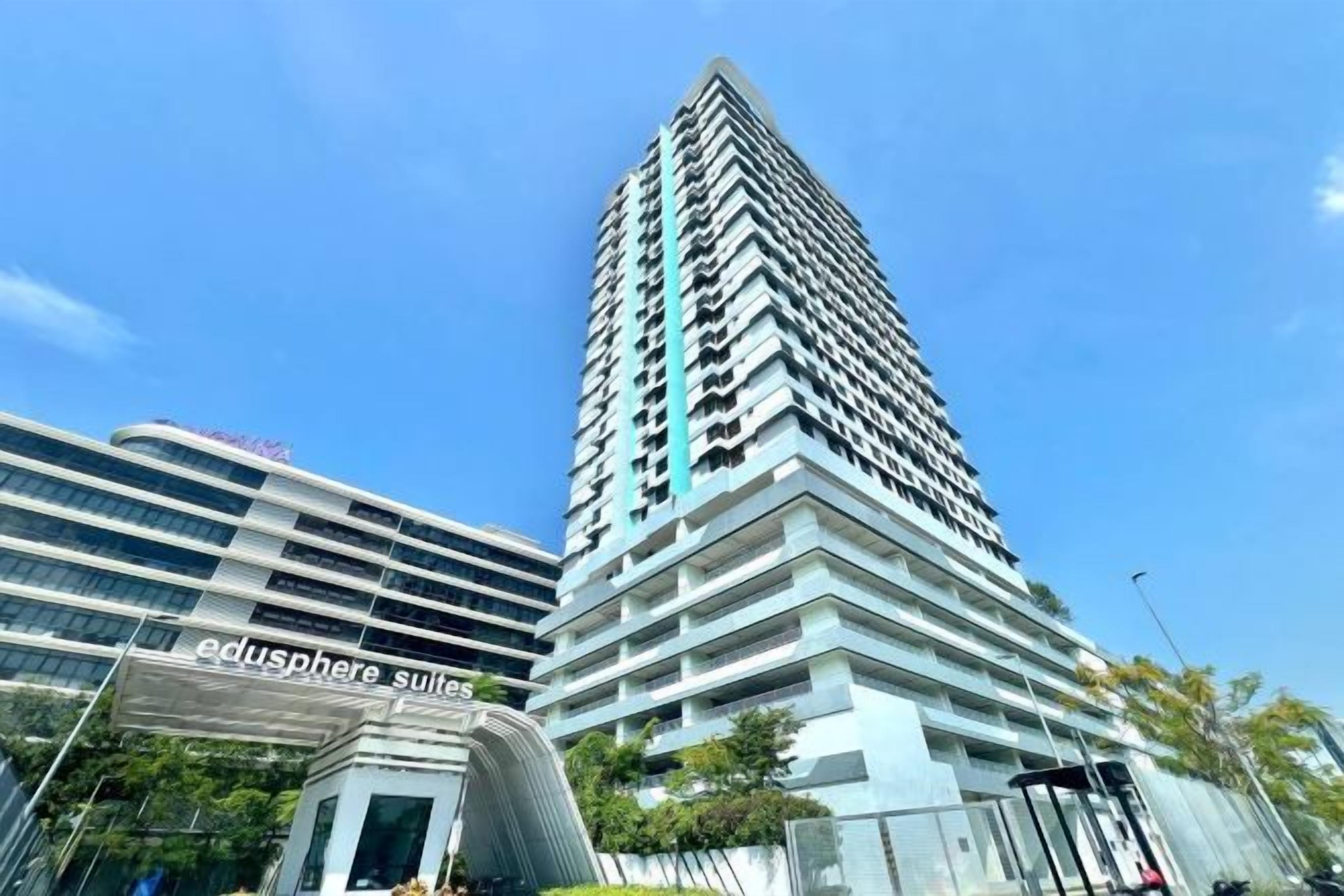 A high-rise building with a modern architectural design, featuring multiple balconies and a prominent entrance.