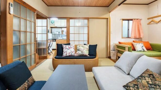 Une pièce de style japonais traditionnel, avec un sol recouvert de tatamis, un plafond bas en bois et des portes coulissantes.