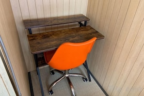Escritorio en esquina con una silla, una mesa de madera y estructura metálica.