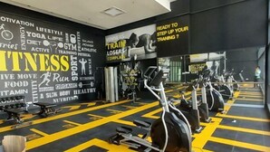 A gym with exercise equipment, motivational posters, and a black and yellow floor design. - Shahdila @ Alinea (Shah Alam)