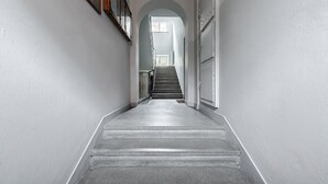 A narrow hallway with a staircase leading to a landing. - Lumina Apart for family in the Old Town (Warsaw)