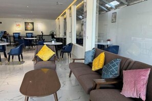 A modern lounge area with sofas, chairs, and a coffee table. - Westport Hotel Boutique (Sihanoukville)