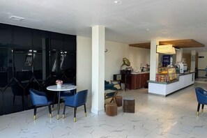 A modern hotel lobby with a bar area, seating, and a marble floor. - Westport Hotel Boutique (Sihanoukville)