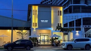 Hotel "West Port" con terraza al aire libre y un paso de cebra en la calle.