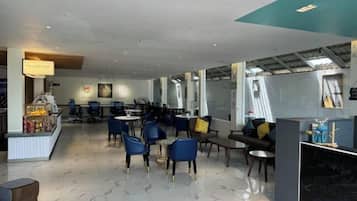 A modern cafe with seating arrangements, a coffee machine, and a counter.