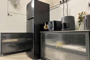 A kitchen with a black refrigerator, a microwave, and a coffee maker on a counter. - Corner House Puchong 18 pax BBQ Kid Friendly (Puchong)