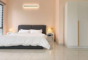 A modern bedroom with a bed, bedside tables, a nightstand, and a wardrobe.