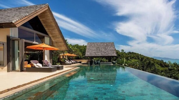 A modern resort with an infinity pool, lounge chairs, and umbrellas. - Purana Residence (Koh Samui)