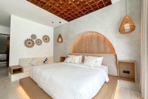 Une chambre moderne avec un grand lit, une tête de lit en bois et un plafond orné d’un motif géométrique.