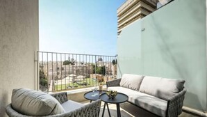 A balcony with a sofa, two chairs, and a small table. - Modern and Vibrant 1BR apt with Private Balcony (Tel Aviv)